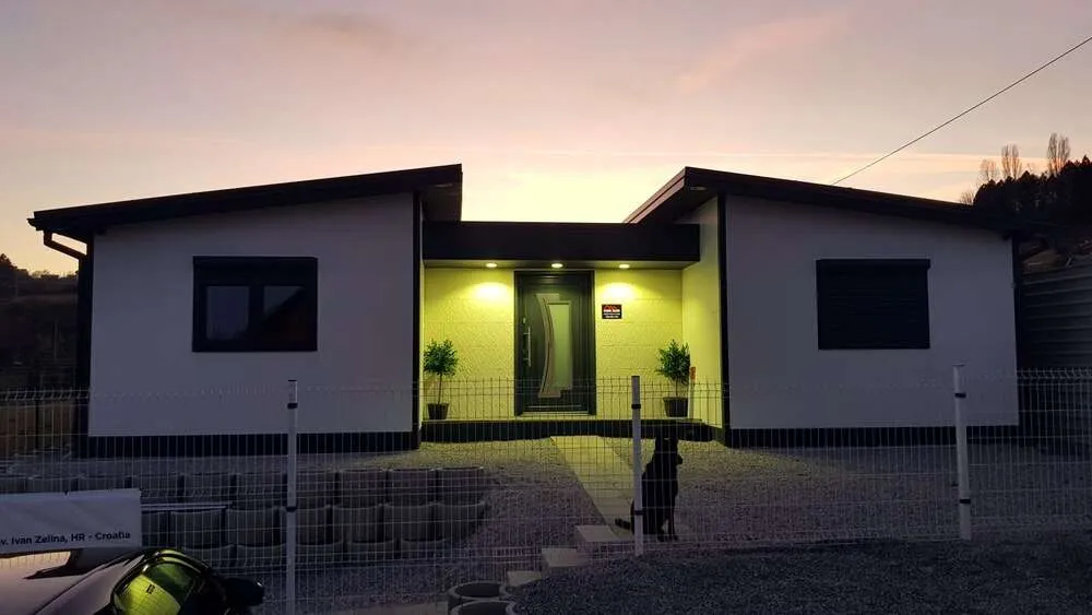 marida 120 modelo de casa modular vista desde el exterior al atardecer con un perro en el jardín delantero